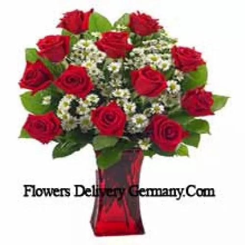 11 красных роз с папоротниками в стеклянной вазе