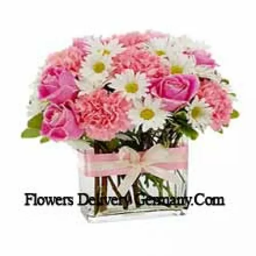 Rosas rosadas, claveles rosados y flores blancas variadas dispuestas hermosamente en un jarrón de vidrio